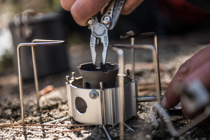 Leatherman Skeletool multi-tool with pliers clamping a cookware pot while cooking