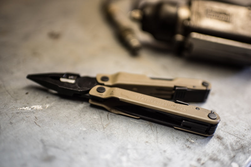 Coyote tan 17-in-1 multi-tool lying closed with tools folded out