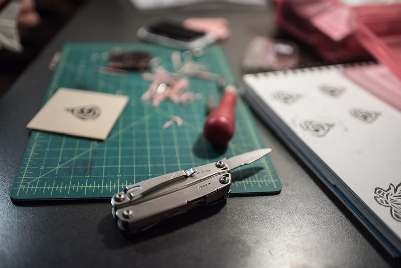 Stainless steel multi-tool with blades and handles, closed on work surface