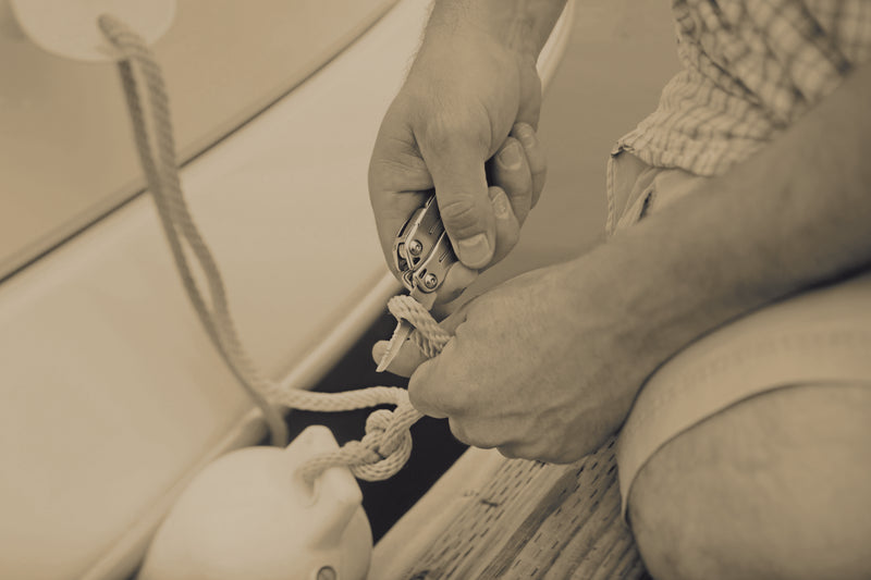 Small metal multi-tool in hand adjusting a cord knot