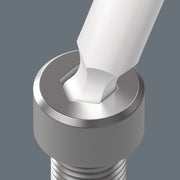 Silver bottle opener head with notched jaw, held above a bottle cap