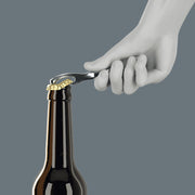 Bottle opener in chrome finish with Wera branding, held by white glove